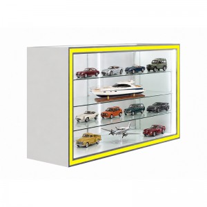 Model cars and larger scale models arranged with space around their bases inside a glass cabinet (2)